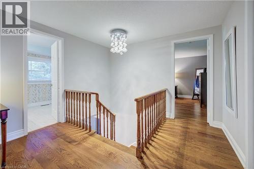 Hallway with wood-finish flooring, white trim, and a contemporary ceiling light fixture - 41 Mcniven Road, Ancaster, ON - Indoor Photo Showing Other Room