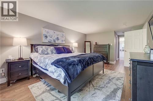 Spacious bedroom featuring wood-finish flooring, light grey wall paint, and white trim - 41 Mcniven Road, Ancaster, ON - Indoor Photo Showing Bedroom