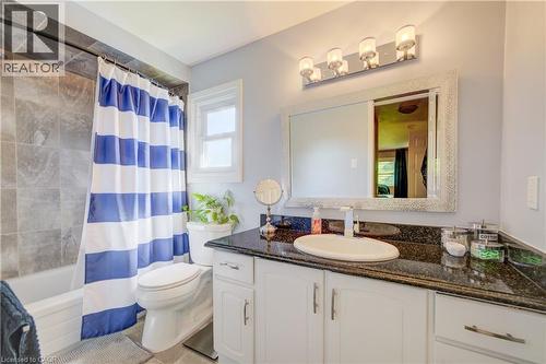 Bathroom featuring a white vanity with a dark countertop, an oval undermount sink, and a modern chrome faucet - 41 Mcniven Road, Ancaster, ON - Indoor Photo Showing Bathroom