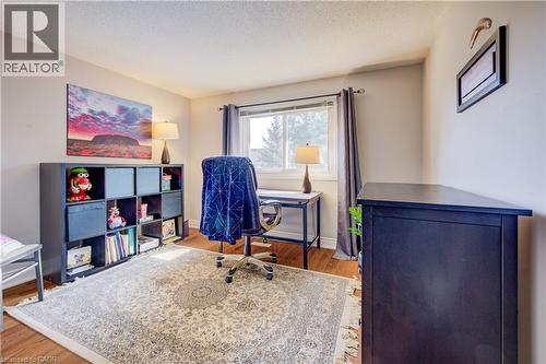 Bright room featuring wood-finish flooring, a large window with drapes, and neutral wall tones - 41 Mcniven Road, Ancaster, ON - Indoor