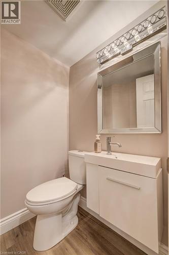 Bathroom featuring a modern floating vanity with an integrated sink, polished chrome faucet, and a large mirrored medicine cabinet with integrated lighting - 41 Mcniven Road, Ancaster, ON - Indoor Photo Showing Bathroom