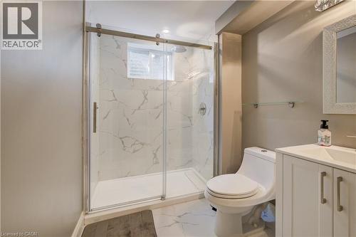 Contemporary bathroom featuring a spacious glass-enclosed shower with marble-look tile surround and a window - 41 Mcniven Road, Ancaster, ON - Indoor Photo Showing Bathroom