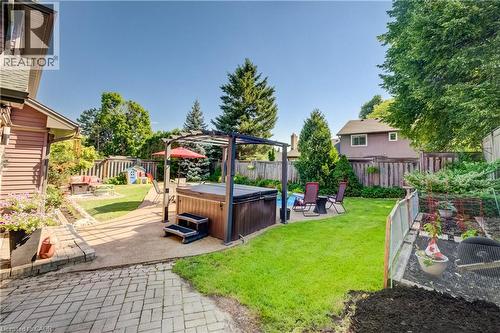 Expansive backyard featuring a hot tub with pergola, an inground pool, and a fire pit area - 41 Mcniven Road, Ancaster, ON - Outdoor With Backyard