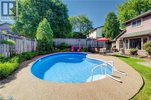 Curved inground pool with textured aggregate decking - 41 Mcniven Road, Ancaster, ON - Outdoor With In Ground Pool With Backyard