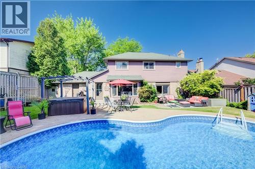 Expansive backyard featuring an in-ground swimming pool, a dedicated patio space, and a pergola-covered hot tub area - 41 Mcniven Road, Ancaster, ON - Outdoor With In Ground Pool With Deck Patio Veranda