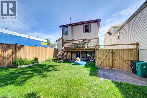 Spacious backyard featuring a manicured lawn, wood privacy fencing, and a multi-level deck with stairs - 39 Kerr Street, Cambridge, ON - Outdoor