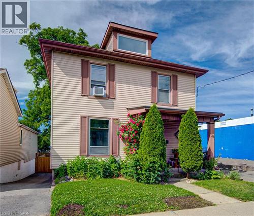 Two-story residence featuring light-colored horizontal siding and a dormer window - 39 Kerr Street, Cambridge, ON - Outdoor