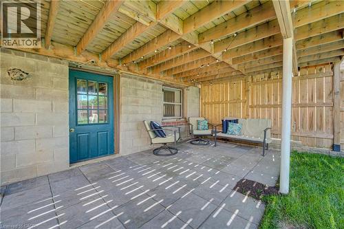 Covered patio area featuring a paver surface, wood-plank ceiling, and a teal-painted door with divided light windows - 39 Kerr Street, Cambridge, ON -  With Deck Patio Veranda With Exterior