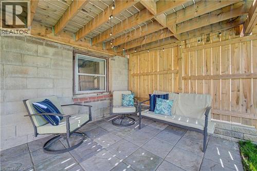 Covered patio featuring a wood ceiling with exposed beams, paver flooring, and a privacy fence - 39 Kerr Street, Cambridge, ON -  With Deck Patio Veranda With Exterior