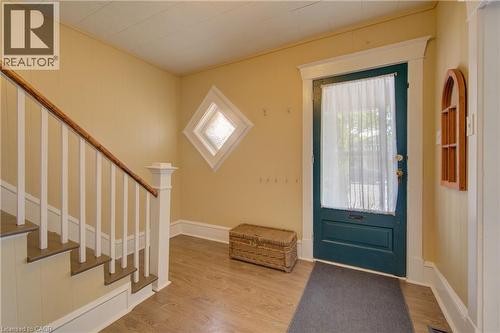 Entryway featuring a dark green paneled door with white trim, wood-finish flooring, and a staircase with white balusters and a wood-finish handrail - 39 Kerr Street, Cambridge, ON - Indoor Photo Showing Other Room