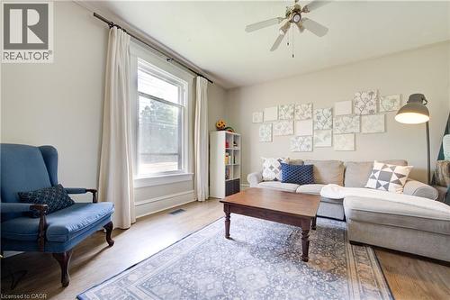 Spacious living area featuring wood-finish flooring, a large window with white trim, and a ceiling fan - 39 Kerr Street, Cambridge, ON - Indoor Photo Showing Living Room