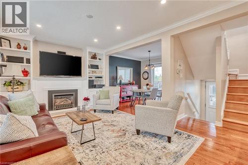 Living area featuring a built-in fireplace, recessed lighting, hardwood flooring, built-in shelving, and crown molding - 851 Beach Boulevard, Hamilton, ON - Indoor Photo Showing Living Room With Fireplace