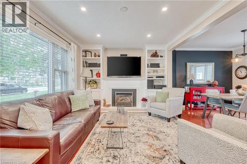 Living room featuring a fireplace with a white mantel, built-in shelving, recessed lighting, hardwood flooring, and crown molding - 851 Beach Boulevard, Hamilton, ON - Indoor Photo Showing Living Room With Fireplace