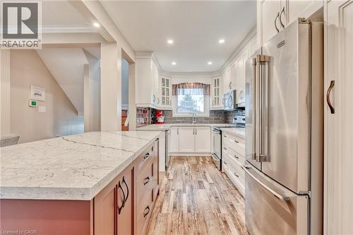 Kitchen featuring a generous island with a light-toned countertop, wood-finish flooring, white cabinetry, stainless steel appliances, and recessed lighting - 851 Beach Boulevard, Hamilton, ON - Indoor Photo Showing Kitchen