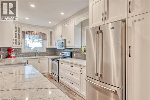 Bright kitchen featuring white cabinetry, stone countertops, a tile backsplash, stainless steel appliances, and recessed lighting - 851 Beach Boulevard, Hamilton, ON - Indoor Photo Showing Kitchen With Upgraded Kitchen