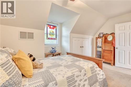 Bedroom featuring a sloped ceiling, carpet flooring, and a window with an artistic glass panel - 851 Beach Boulevard, Hamilton, ON - Indoor Photo Showing Bedroom