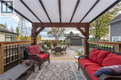 Expansive outdoor deck featuring a wooden railing with black balusters, a wood-beam pergola structure, and a translucent panel roof - 851 Beach Boulevard, Hamilton, ON - Outdoor With Deck Patio Veranda With Exterior
