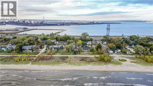 Expansive waterfront property featuring a sandy beach, mature trees, and direct access to Lake Ontario - 851 Beach Boulevard, Hamilton, ON - Outdoor With Body Of Water With View