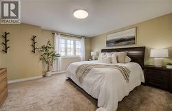 Carpeted bedroom featuring a large window with white trim, a flush-mount ceiling light, and light-toned wall paint - 