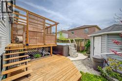 Multi-level wood deck featuring a covered pergola, lattice privacy screens, and a built-in spa - 