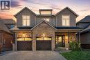 Two-story residential exterior featuring a stone and brick facade, double garage with arched windows, prominent front porch with pillars, and gabled rooflines - 7 Kinsman Drive, Binbrook, ON  - Outdoor 