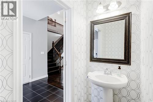 Pedestal sink with chrome faucet, framed mirror, and two-light vanity fixture - 7 Kinsman Drive, Binbrook, ON - Indoor Photo Showing Bathroom