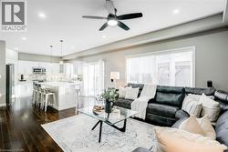 Open-concept living space featuring rich wood-finish flooring, recessed lighting, and a modern ceiling fan - 
