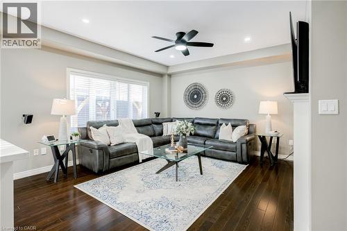 Spacious living area featuring wood-finish flooring, a large window with blinds, recessed lighting, and a ceiling fan - 7 Kinsman Drive, Binbrook, ON - Indoor Photo Showing Living Room