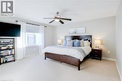 Spacious room featuring light-colored carpeting and a window with white drapery - 