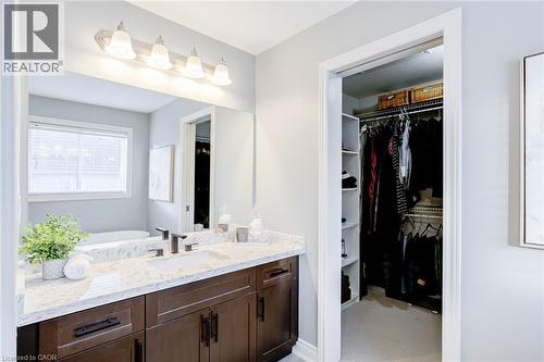 Bathroom featuring a dual-sink vanity with a light-toned countertop, dark wood-finish cabinetry, and matte black fixtures - 7 Kinsman Drive, Binbrook, ON - Indoor Photo Showing Bathroom