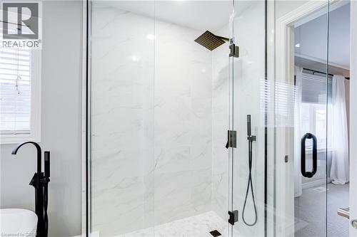 Glass-enclosed shower featuring large format white tile walls, a rain shower head, and an additional handheld shower fixture - 7 Kinsman Drive, Binbrook, ON - Indoor Photo Showing Bathroom