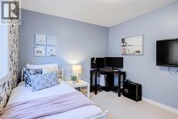Bedroom featuring a single window, light blue walls, and a patterned accent wall - 