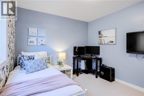 Bedroom featuring a single window, light blue walls, and a patterned accent wall - 7 Kinsman Drive, Binbrook, ON - Indoor Photo Showing Bedroom