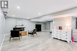 Spacious room featuring light wood-finish flooring, recessed lighting, and light grey wall tones - 