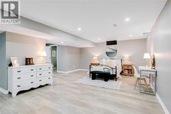 Spacious room featuring light wood-finish flooring, recessed lighting, and neutral wall tones - 