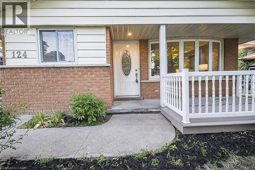 Brick facade with light-colored siding, a covered front porch featuring white railings, and a curved concrete walkway - 124 Dunsmere Drive, Kitchener, ON - Outdoor With Deck Patio Veranda