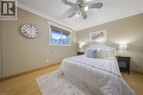 Bedroom featuring light wood-finish flooring, crown molding, a ceiling fan with integrated lighting, and a window with blinds - 124 Dunsmere Drive, Kitchener, ON - Indoor Photo Showing Bedroom