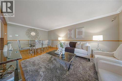 Open-concept living and dining area featuring wood-finish flooring, crown molding, and a neutral color palette - 124 Dunsmere Drive, Kitchener, ON - Indoor Photo Showing Living Room