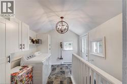 Laundry room featuring an abundance of white cabinetry, a top-load washer and dryeR - 