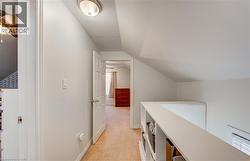 Carpeted hallway with sloped ceilings and a built-in bookshelf railing - 