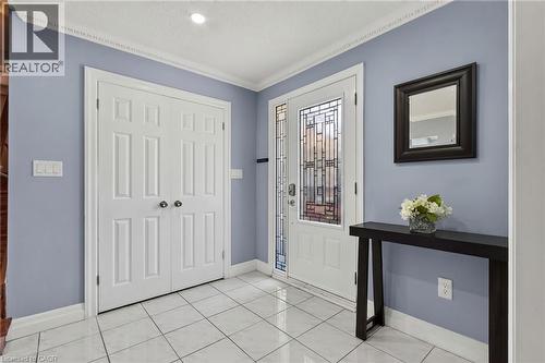 Entryway featuring a white tile floor, a decorative glass front door, and a two-panel bifold door - 1172 Chada Avenue, Mississauga, ON - Indoor Photo Showing Other Room