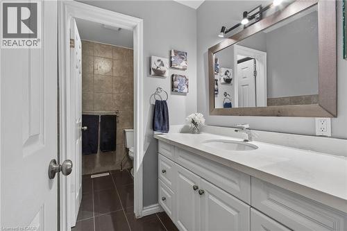 Bathroom vanity featuring a light-toned countertop, integrated sink, and white shaker-style cabinetry - 1172 Chada Avenue, Mississauga, ON - Indoor Photo Showing Bathroom