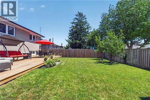Expansive backyard featuring a well-maintained lawn, privacy fencing, mature trees, a wooden deck, and a planted border - 1172 Chada Avenue, Mississauga, ON - Outdoor With Deck Patio Veranda