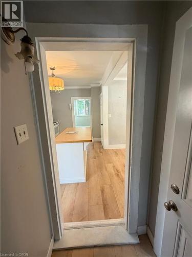Interior doorway revealing wood-finish flooring and a kitchen island with a light wood countertop - 104 Marshall Street, Waterloo, ON - Indoor Photo Showing Other Room