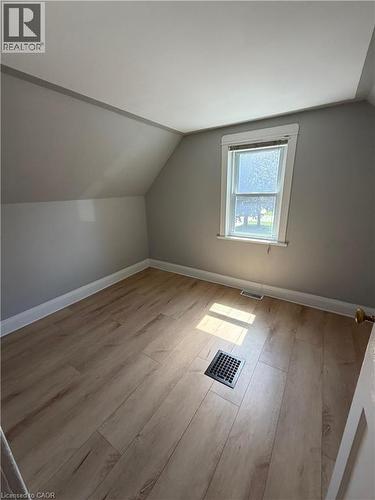 Room featuring wood-finish flooring, a window with natural light, a floor register, a baseboard register, and white trim - 104 Marshall Street, Waterloo, ON - Indoor Photo Showing Other Room