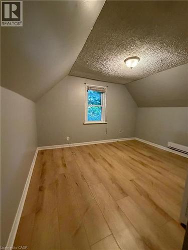 Room featuring wood-finish flooring, a single window with blinds, and a flush mount ceiling light fixture - 104 Marshall Street, Waterloo, ON - Indoor Photo Showing Other Room