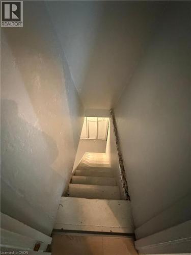 Straight staircase with painted risers and treads, framed by light-toned walls and a visible wall base trim - 104 Marshall Street, Waterloo, ON - Indoor Photo Showing Other Room