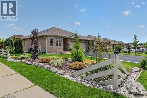 Brick and stone exterior with an attached garage, bay window, and a gabled roofline - 51 Millcroft Drive, Simcoe, ON - Outdoor