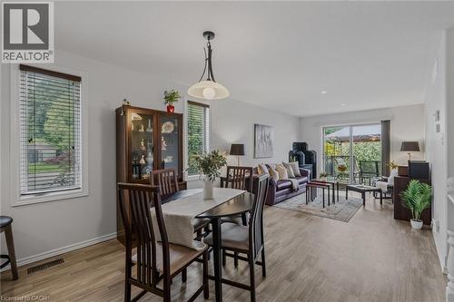 Open-concept living and dining area featuring wood-finish flooring, recessed lighting, and a sliding glass door to an outdoor patio - 51 Millcroft Drive, Simcoe, ON - Indoor Photo Showing Dining Room