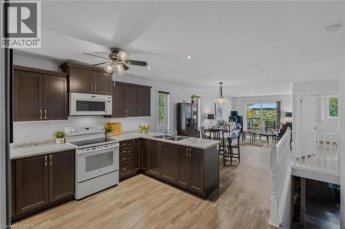 Kitchen featuring dark wood cabinetry, light-toned countertops, and wood-finish flooring - 51 Millcroft Drive, Simcoe, ON - Indoor Photo Showing Kitchen With Double Sink